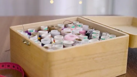 Multicolored embroidery sewing threads lie in wooden box. person body part hand Stock Footage 329285100