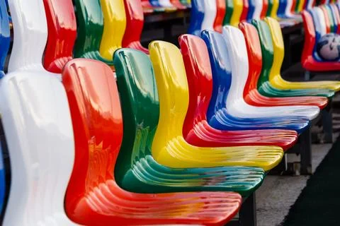 Multicolored empty plastic seats, chairs in the stadium. Stock Photos