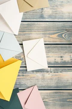 Multicolored envelopes lie randomly on gray wooden background. Copy space Stock Photos