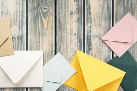 Multicolored envelopes lie randomly on gray wooden background. Copy space. Top Stock Photos
