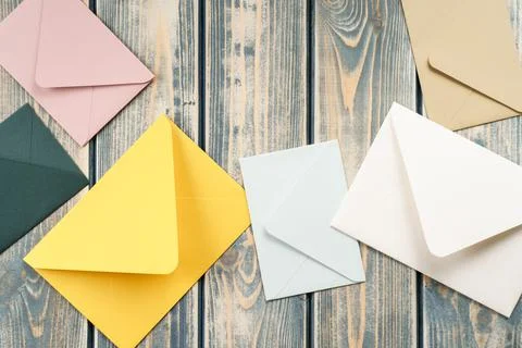 Multicolored envelopes lie randomly on gray wooden background. Copy space. Top Stock Photos
