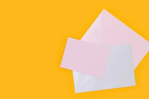 Multicolored envelopes on a yellow background. Stock Photos