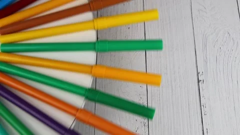 Multicolored felt-tip pens rotate on a round table on a wooden background Stock Footage 140403013