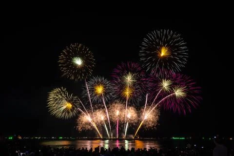 Multicolored Fireworks Display Reflecting Over Dark Water Night Scene Wide Sh Foto stock