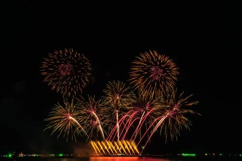 Multicolored Fireworks Displaying Floral Patterns Above Reflecting Water Ni.. 库存照片
