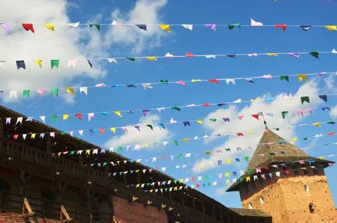 Multicolored flags on blue sky background and white clouds. Stock Photos