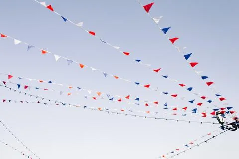 Multicolored flags flutter in the wind over a street fair Stock Photos