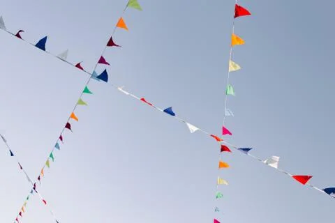 Multicolored flags flutter in the wind over a street fair Stock Photos