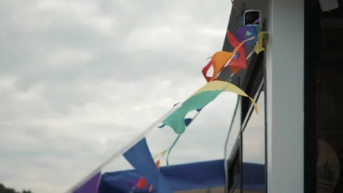 Multicolored flags hanging from a rope flutter in the wind Stock Footage 138584605