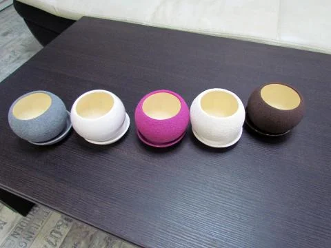 Multicolored flower pots, round shape on the table Stock Photos