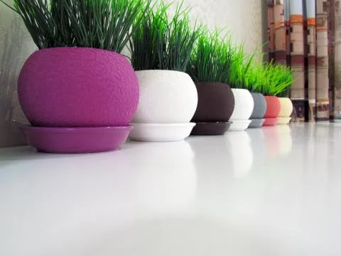 Multicolored flower pots, round shape on the table Stock Photos