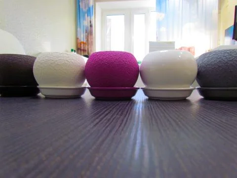 Multicolored flower pots, round shape on the table Stock Photos