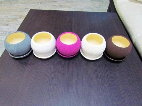 Multicolored flower pots, round shape on the table Stock Photos