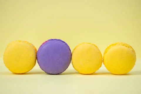 Multicolored fresh macarons on a yellow background. Stock Photos