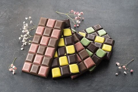 Multicolored fruit chocolate bars on black background. Handmade chocolate with Stock Photos