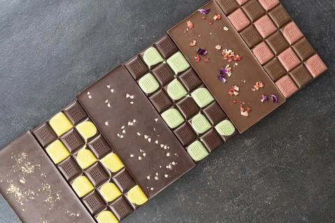 Multicolored fruit chocolate bars on black background. Handmade chocolate with Stock Photos