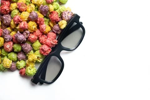 Multicolored fruit flavored popcorn with cinema 3D glasses on pink background Stock Photos