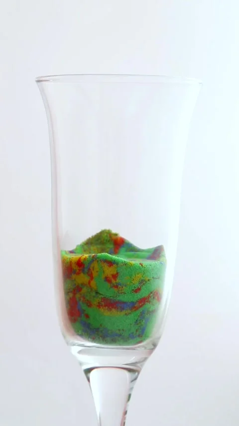 Multicolored geometric figures made of kinetic sand are crushed in a glass mug. Stock Footage 277227109