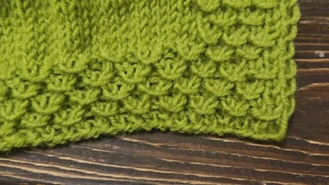Multicolored hand-knitted fabric. Knitting and crochet lessons. Fashion Stock Footage 345023277