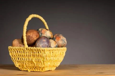 Multicolored hand painted easter eggs in the yellow basket Stock Photos