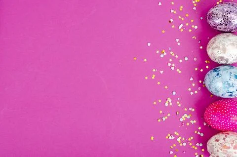 Multicolored handmade easter eggs and confetti on pink background. Minimal .. Stock Photos