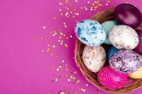 Multicolored handmade easter eggs and confetti on pink background. Minimal .. Stock Photos