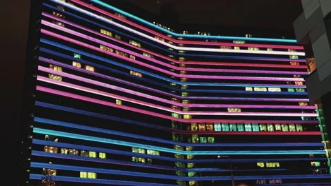 Multicolored illumination on a tall building. Rapidly changing color lines Stock Footage 162347711