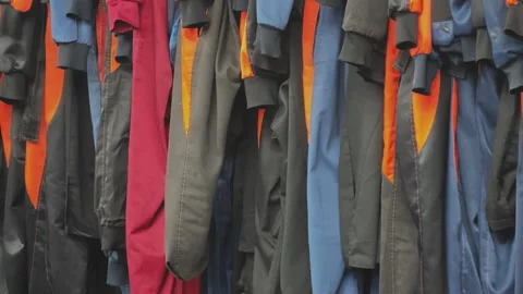 Multicolored jumpsuits for skydiving hanging in a row in a locker room Video stock 345679631