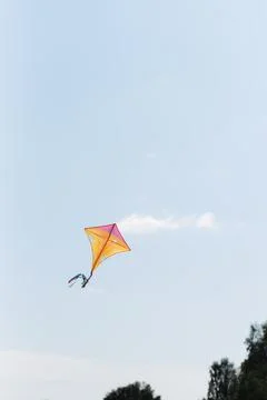 Multicolored kite on the background of the summer blue sky Stock Photos