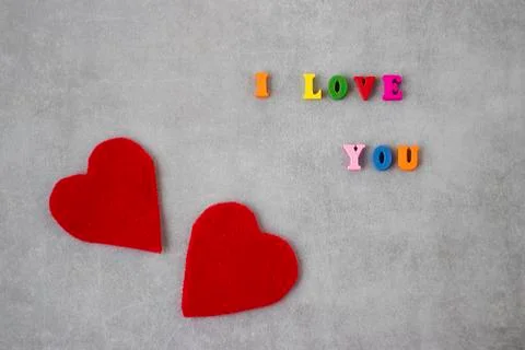 Multicolored letters and two red decorative hearts on gray background. I love Stock Photos