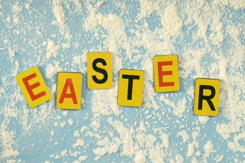 Multicolored letters arranged in the word "Easter" on a blue background wit.. Stock Photos