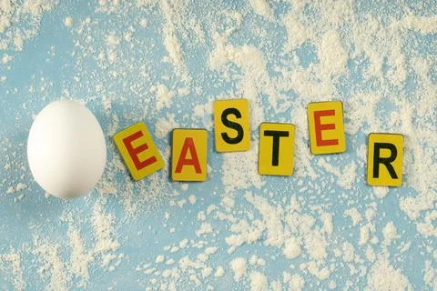 Multicolored letters arranged in the word "Easter" on a blue background wit.. Stock Photos