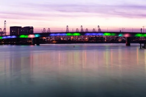 Multicolored lighted bridge over bay at sunset long exposure Stock Photos
