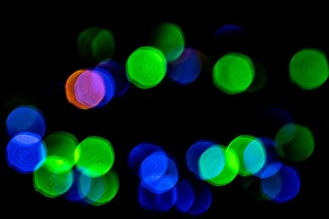 Multicolored lights in soft focus on a black background bokeh Stock Photos