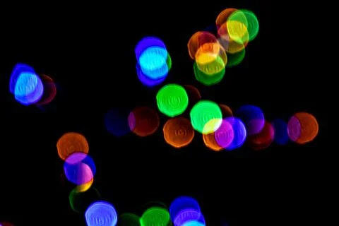 Multicolored lights in soft focus on a black background bokeh Stock Photos