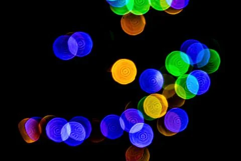 Multicolored lights in soft focus on a black background bokeh Stock Photos