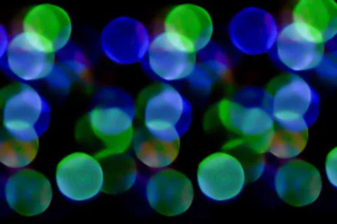 Multicolored lights in soft focus on a black background bokeh Stock Photos