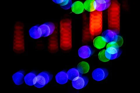 Multicolored lights in soft focus on a black background bokeh Stock Photos
