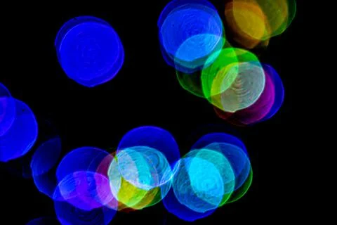 Multicolored lights in soft focus on a black background bokeh Stock Photos