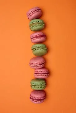 Multicolored macarons on a orange background, top view, dessert Stock Photos