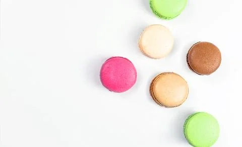 Multicolored macarons on a white background top view with copy space Stock Photos