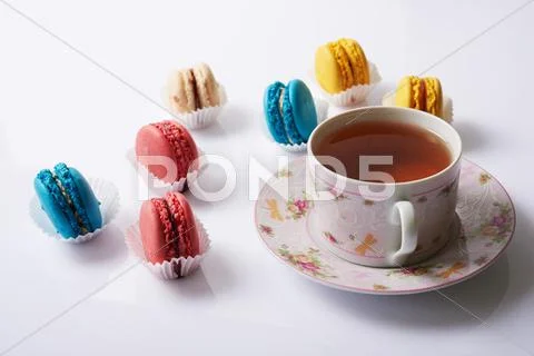 Multicolored macaroon and tea on a white background Stock Photos