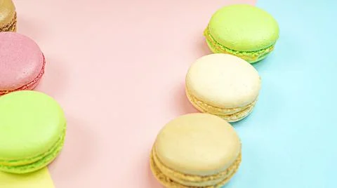 Multicolored macaroon cakes on colored bedding background with copy space Stock Photos