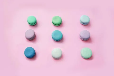 Multicolored macaroon or macaron biscuits on pastel pink background. Stock Photos