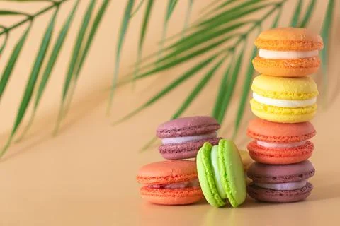 Multicolored macaroons are stacked vertically, copy space Stock Photos