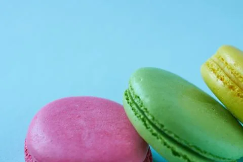 Multicolored macaroons on blue background with space for text. Close-up. Foto stock