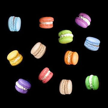 Multicolored macaroons isolated on black background falling or flying in moti Stock Photos
