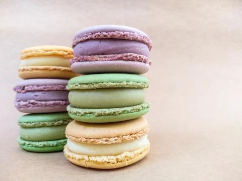 Multicolored macaroons lie on a beige background with place for text. Foto stock