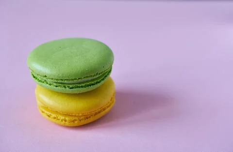 Multicolored macaroons on a pink background. A close-up of cookies. Stock Photos