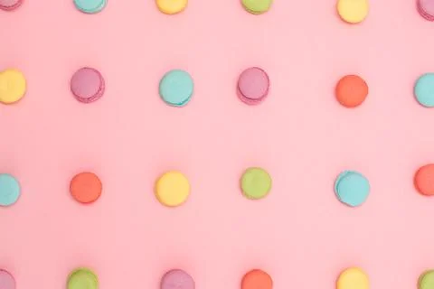 Multicolored macaroons in a row on pink background Stock Photos